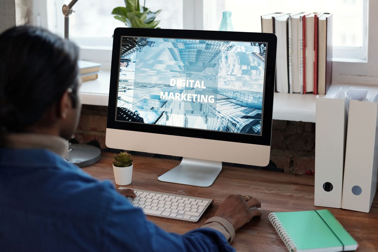 our-experience A person working on digital marketing at a well-organized workspace with a computer.