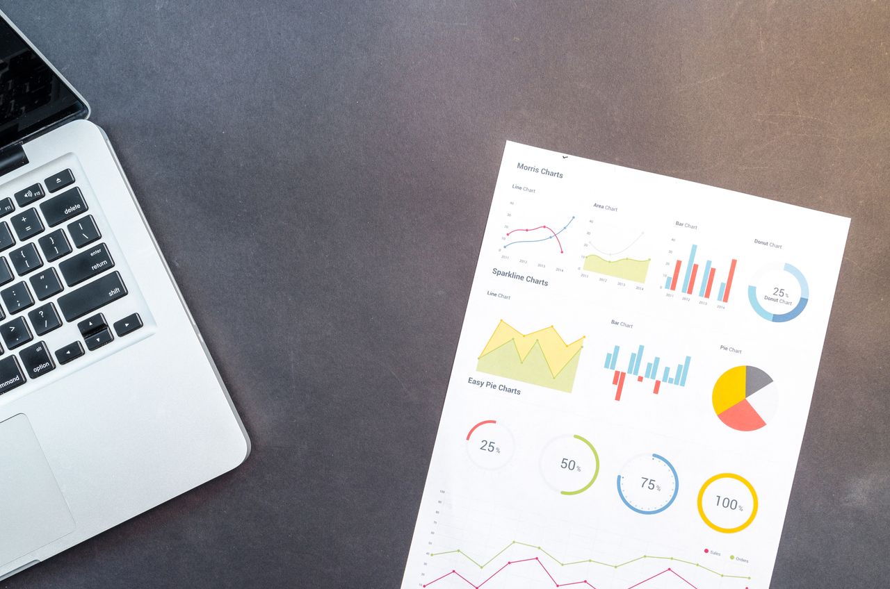 why-choose-us Modern desk setup with a laptop and analytical charts showcasing data interpretation and business analysis.