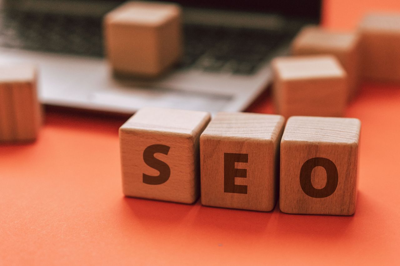 services-03 Wooden blocks spelling SEO on a laptop keyboard convey digital marketing concepts.